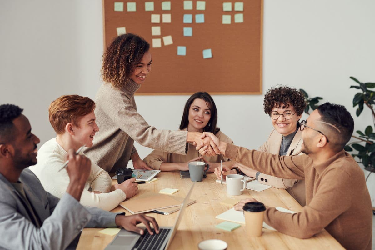 Equipe pedagógica colaborando em reunião com tecnologia e planejamento